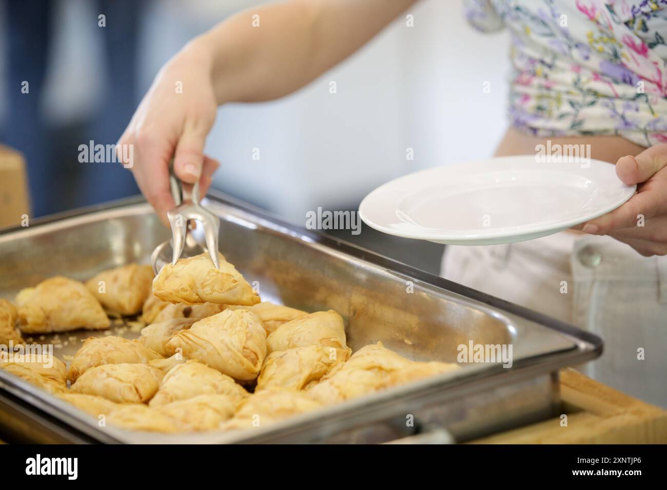 Eine Frau, die Essen von einem Buffet nimmt Stockfoto