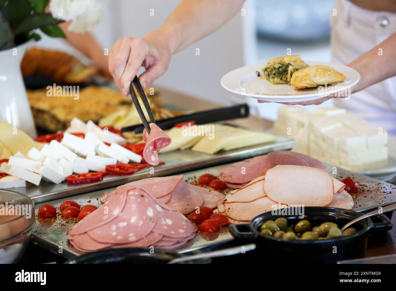 Eine Frau, die Essen von einem Buffet nimmt Stockfoto