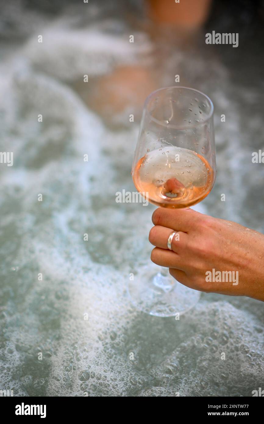 Eine Frau genießt ein entspannendes Bad mit einem Glas Wein. Stockfoto