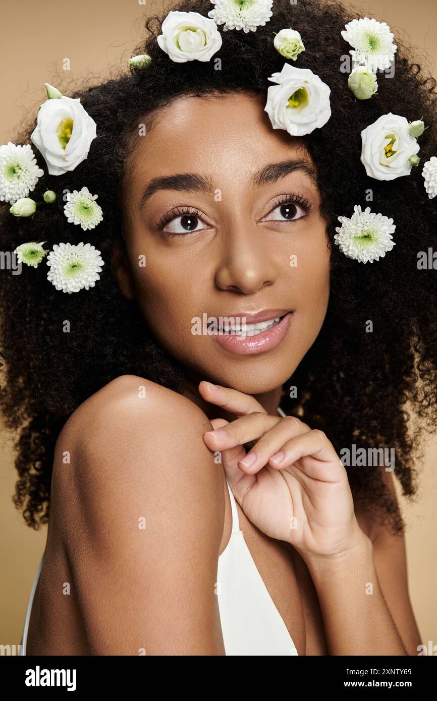 Eine junge afroamerikanische Frau mit einer Blumenkrone im Haar, einem sanften Lächeln und natürlichem Make-up. Stockfoto