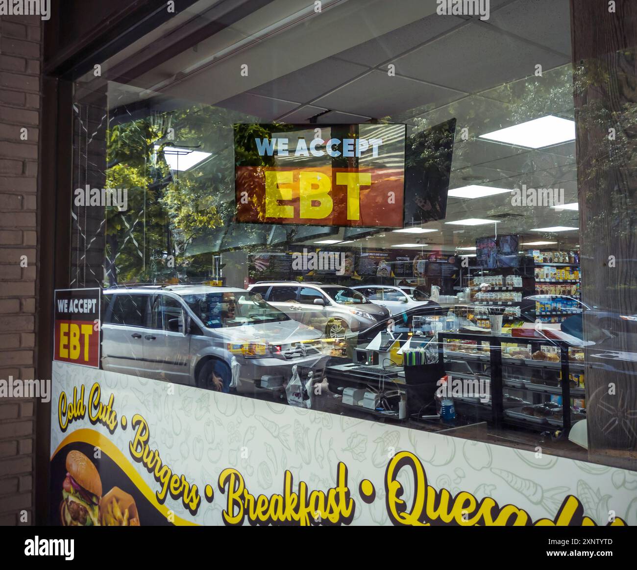 Ein Schild im Fenster eines Lebensmittelgeschäfts in Chelsea in New York gibt an, dass der 24-Stunden-Laden EBT-Mittel (Electronic Benefits Transfer) akzeptiert. Dies ist am Montag, den 29. Juli 2024 zu sehen. (© Richard B. Levine) Stockfoto