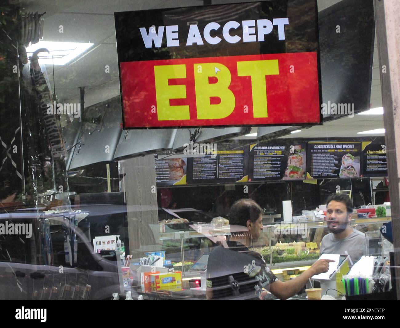 Ein Schild im Fenster eines Lebensmittelgeschäfts in Chelsea in New York gibt an, dass der 24-Stunden-Laden EBT-Mittel (Electronic Benefits Transfer) akzeptiert. Dies ist am Montag, den 29. Juli 2024 zu sehen. (© Richard B. Levine) Stockfoto
