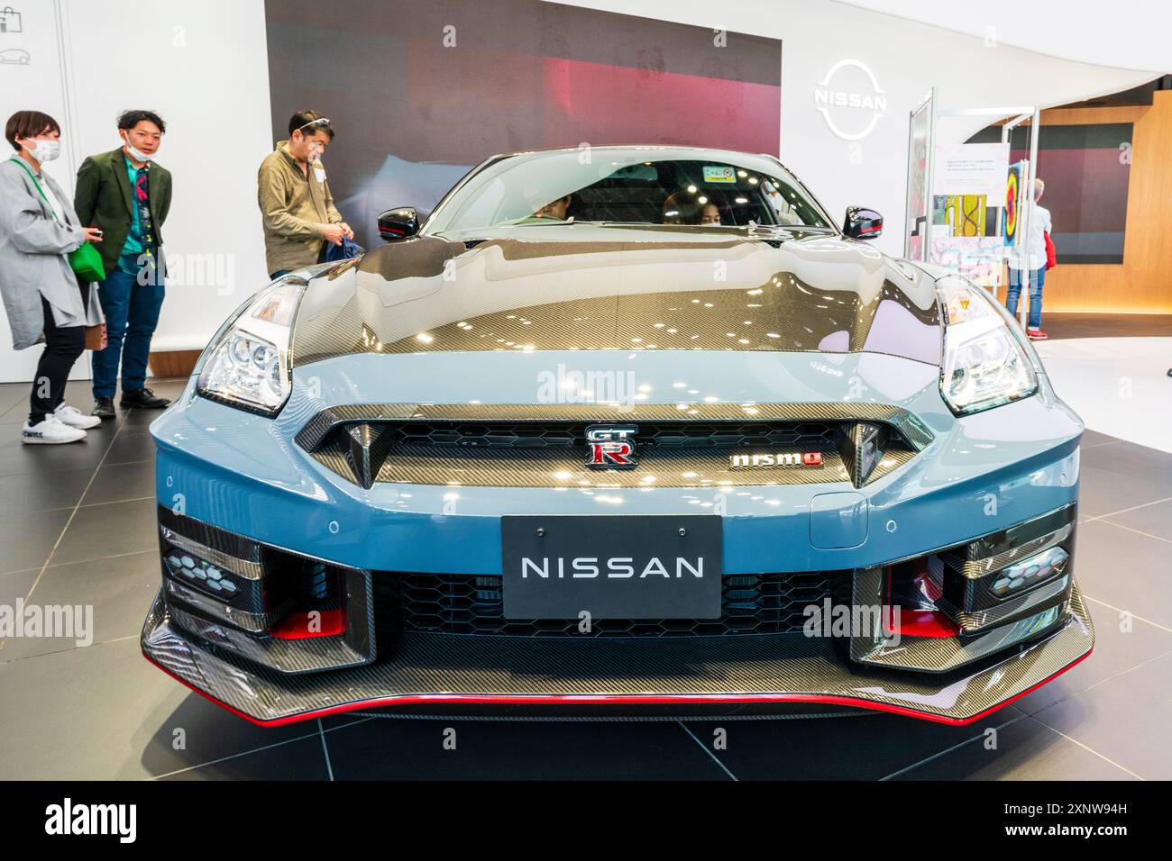 Ein GT-R NISMO-Auto im Nissan Showroom im Ginza Place Gebäude. Niedrige Vorderansicht mit Personen im Fahrzeug und um das Fahrzeug herum. Stockfoto