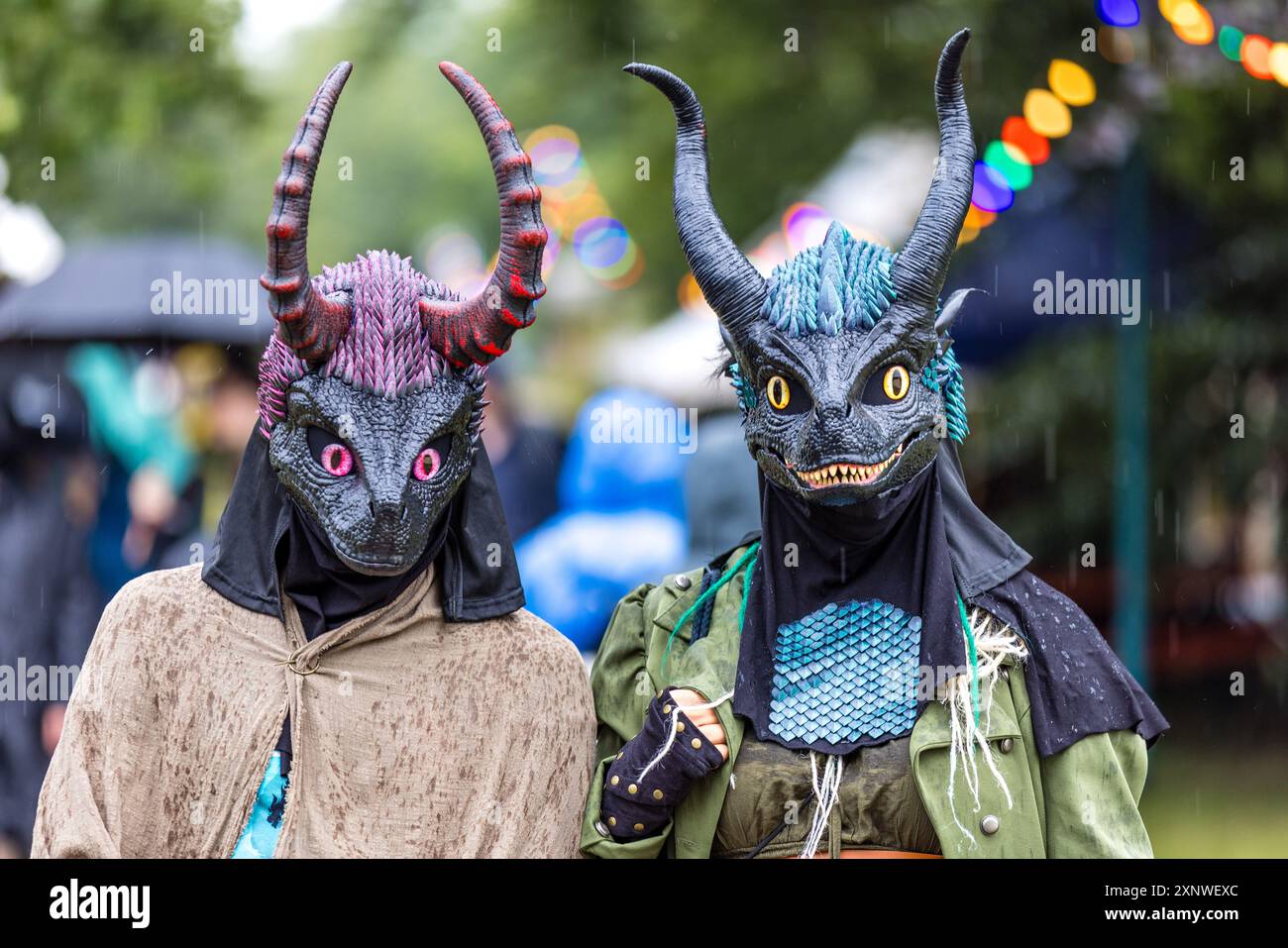 Cottbus, Deutschland. August 2024. Jennyy (r) und Paul aus Rostock nehmen am Elbenwald Festival Teil. Sie laufen in ihren fantasievollen Drachenkostümen im Regen über das Festgelände im Spreeauenpark. Das Elbenwald Festival ist in erster Linie ein Treffpunkt für Fans populärer Science-Fiction- und Fantasy-Serien wie Harry Potter, Star Wars, Lord of the Rings und Marvel Comics. Vermerk: Frank Hammerschmidt/dpa/Alamy Live News Stockfoto