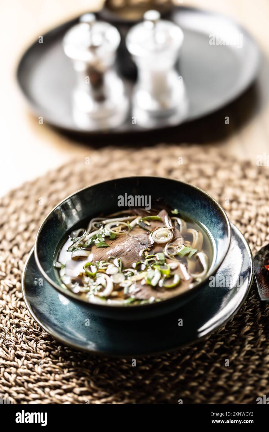 Pho Bo vietnamesische frische Reisnudelsuppe mit Rindfleisch, Zwiebeln, Limette, Kräutern und Chili-Dekoration. Stockfoto
