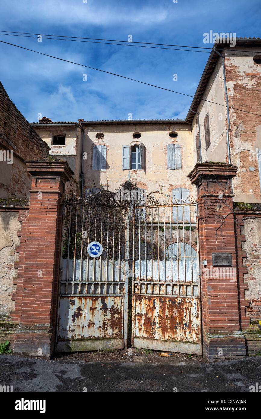 Frankreich, Okzitanien, Gaillac, heruntergekommene Backsteinarchitektur und verrostete Tore am Place Emilie de Vialar Stockfoto