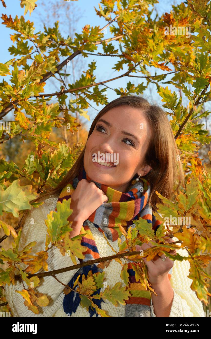 Porträt einer jungen schönen lächelnden Frau, 30 Jahre alt, draußen im Wald mit Herbstfarben in Ystad, Skane County, Schweden, Skandinavien Stockfoto