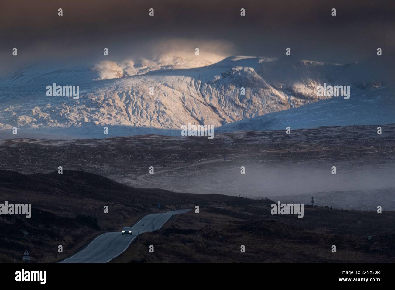 Ein Auto überquert Rannoch Moor mit Beinn a Chreachain und die Grampian Mountains dahinter, Rannoch Moor, Argyll und Bute, Schottland Stockfoto