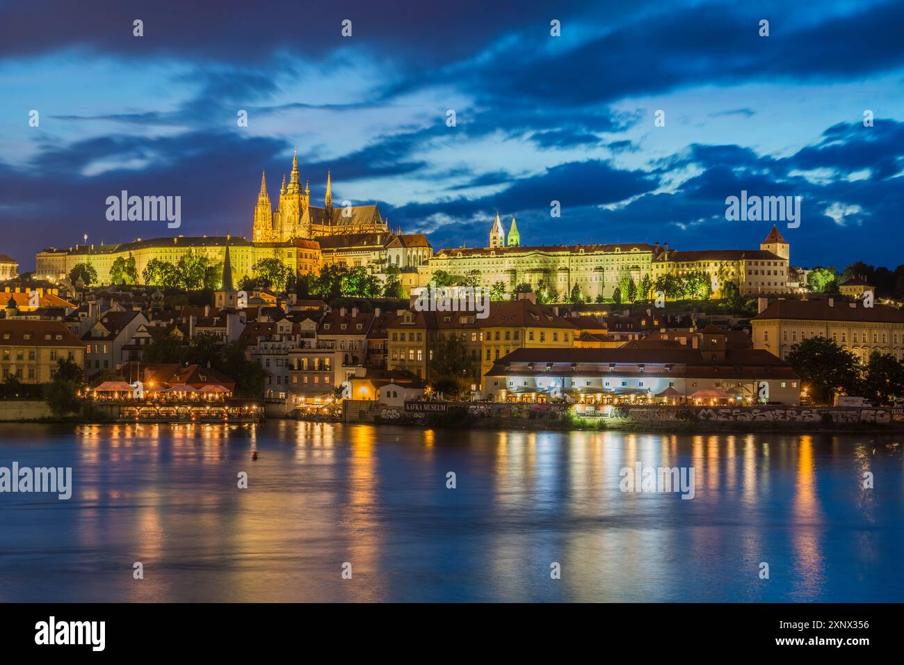 Beleuchtete Prager Burg, die sich in der Dämmerung über der Moldau erhebt, UNESCO-Weltkulturerbe, Prag, Tschechien (Tschechien), Europa Stockfoto