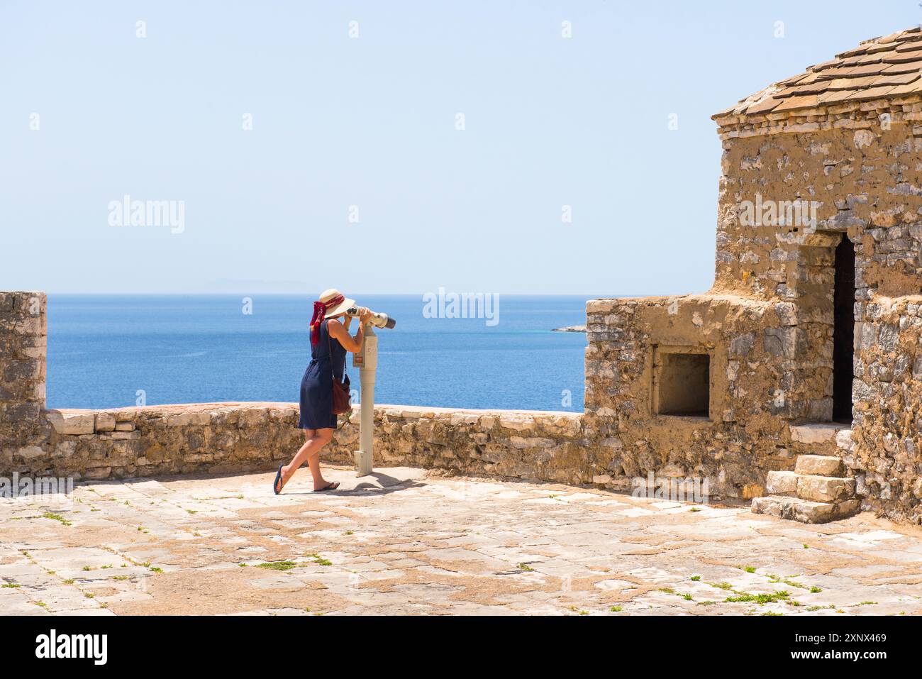 Frau, die durch ein Teleskop auf dem Dach der Festung Ali Pascha Tepelena in Porto Palermo, Ionische Küste, Albanien, Europa blickt Stockfoto