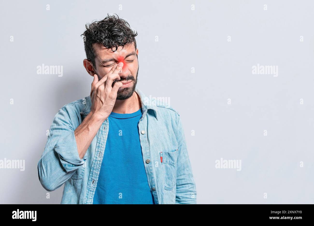 Person mit Schmerzen, die die Nase berühren. Eine Person mit Nasenbrückenschmerzen, Mann mit Nasenbrückenkopfschmerz. Sinusschmerzen Konzept Stockfoto