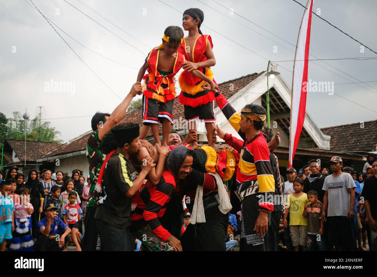 Zwei Jungs, die auf dem Körper einer barong-Tänzerin stehen, geraten in Trance im Dorf Sukomoro, Puncu Kediri, Ost-Java, Indonesien. Stockfoto