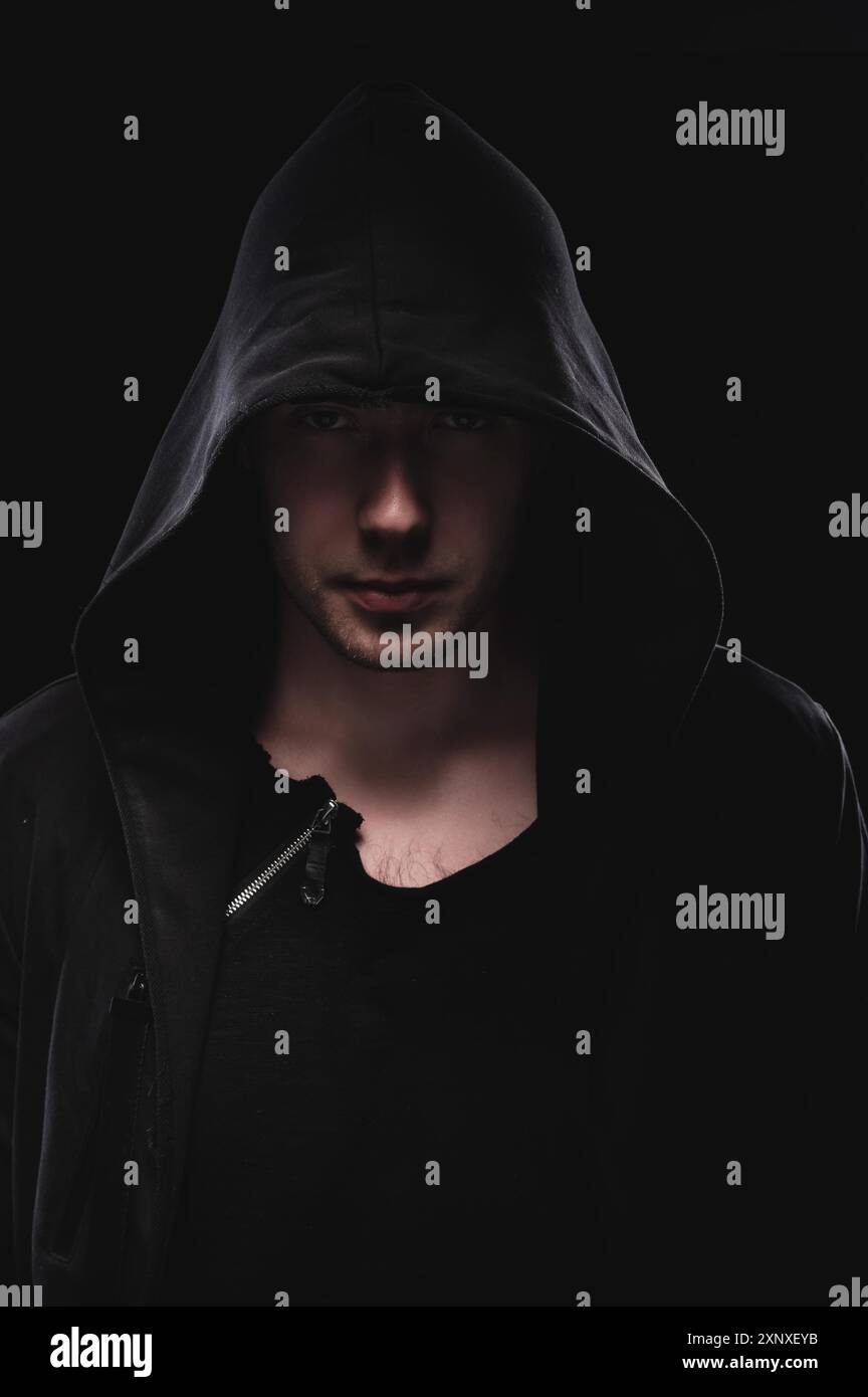 Ein tiefes Porträt eines Mannes in einer mit Kapuze versehenen Handbewegung macht eine Sperma-Helden-Maske. Das Konzept der Anonymität und Privatsphäre Stockfoto
