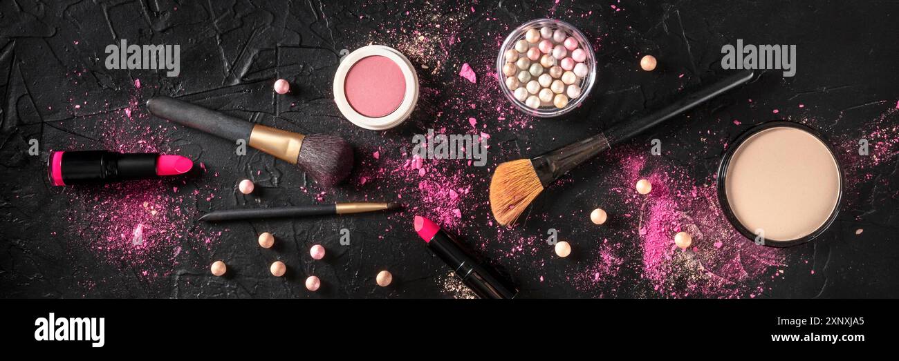 Professionelles Make-up-Panorama auf dunklem Hintergrund. Pinsel, Lippenstift und andere Produkte, eine flache Lage Stockfoto