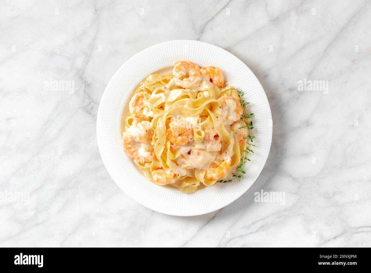 Pasta mit Meeresfrüchten. Pappardelle mit Garnelen und Sahnesauce, von oben mit frischem Thymian erschossen Stockfoto