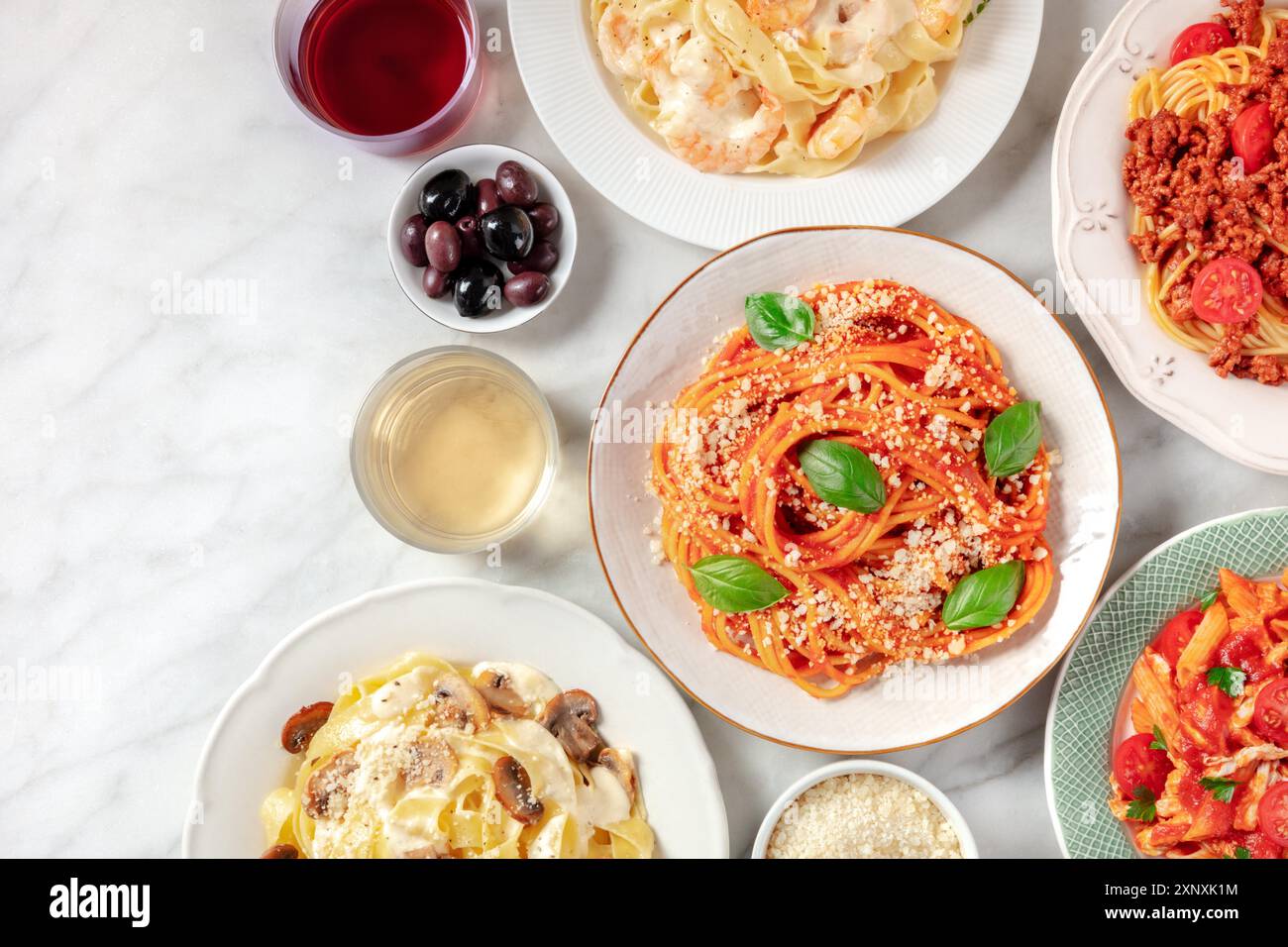 Italienisches Essen, von oben mit einem Platz für Text aufgenommen. Pasta, Oliven, Wein. Spaghetti mit Tomatensauce, Ravioli und anderen Klassikern Stockfoto