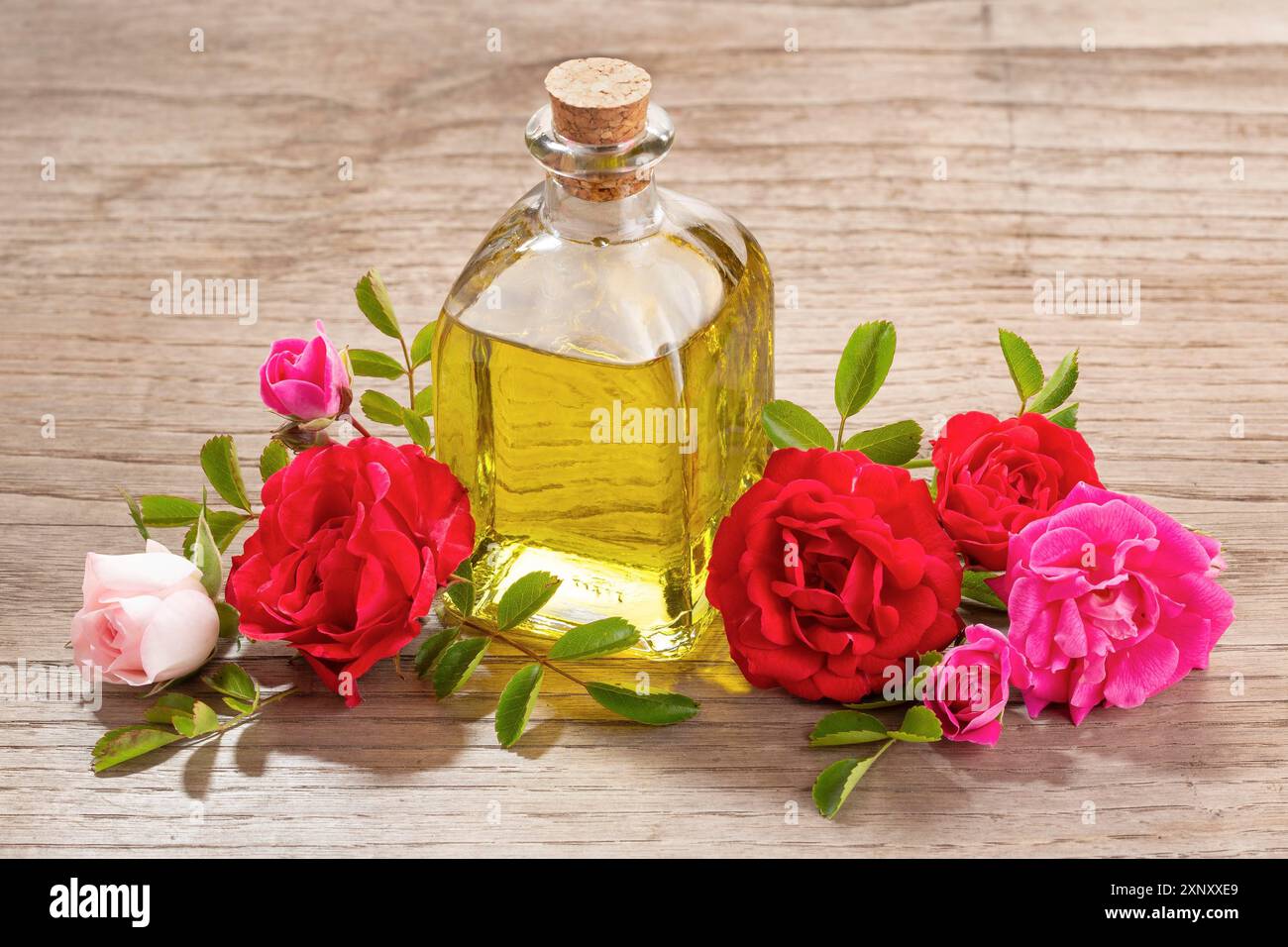 Rose ätherisches Öl in Glas Flasche auf hölzernen Tisch Stockfoto