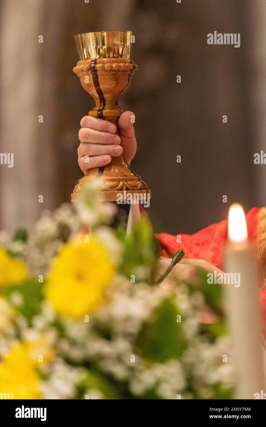 Die Erhebung des Kelch mit dem sakramentalen Wein während der katholischen Eucharistiefeier Stockfoto