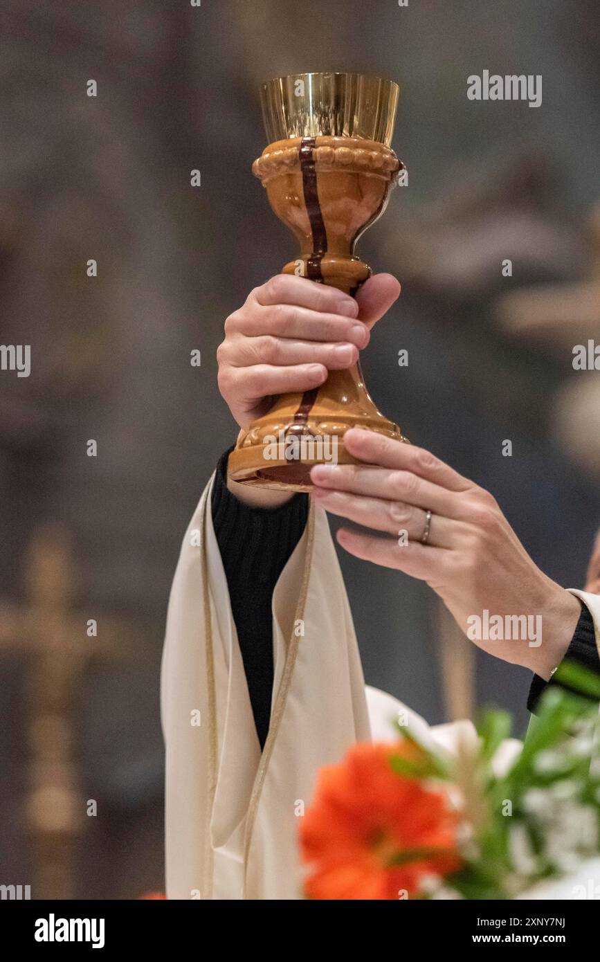 Die Erhebung des Kelch mit dem sakramentalen Wein während der katholischen Eucharistiefeier Stockfoto