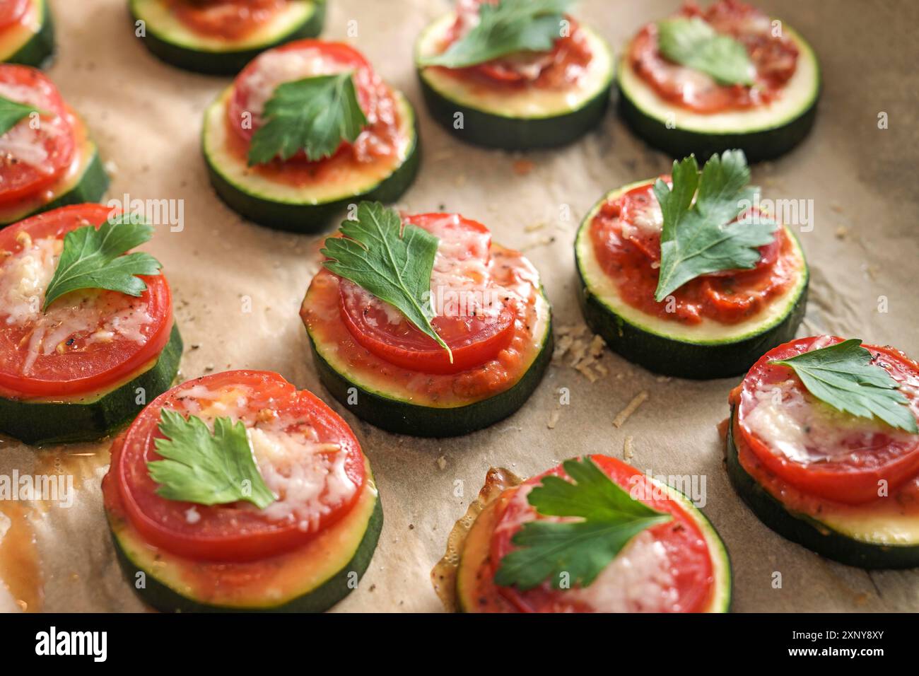 Im Ofen gebackener Zucchini-Snack mit Tomaten-, Käse- und Petersilie-Beilage, vegetarische Mini-Pizza für eine gesunde Low-Carb-Diät, Nahaufnahme mit ausgewähltem Fokus Stockfoto