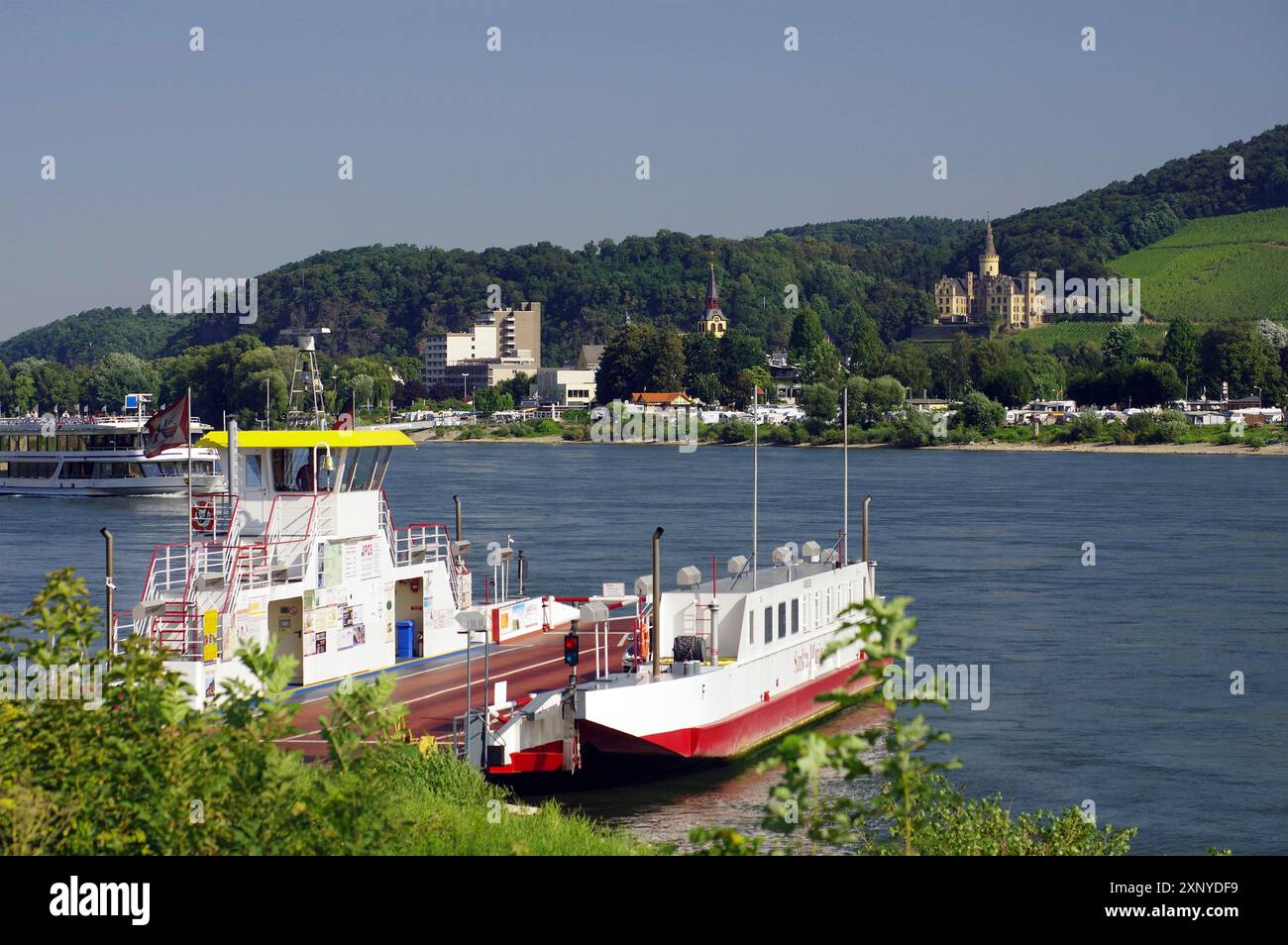 Eine Fähre am Uferufer mit einer Stadt und bewaldeten Hügeln im Hintergrund, Rhein, Andernach, Rheinland-Pfalz, Deutschland Stockfoto