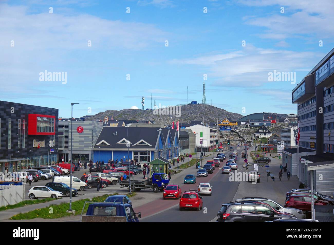 Blick auf die Stadt mit Autos auf der Straße und modernen Gebäuden entlang der Straße, Hügel im Hintergrund, Hauptstadt, Nuuk, Grönland, Dänemark Stockfoto