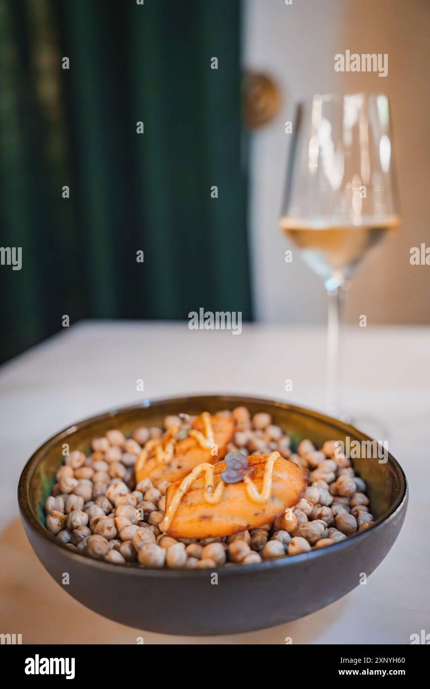 Elegantes Kichererbsengericht mit Weißwein in luxuriöser Atmosphäre Stockfoto