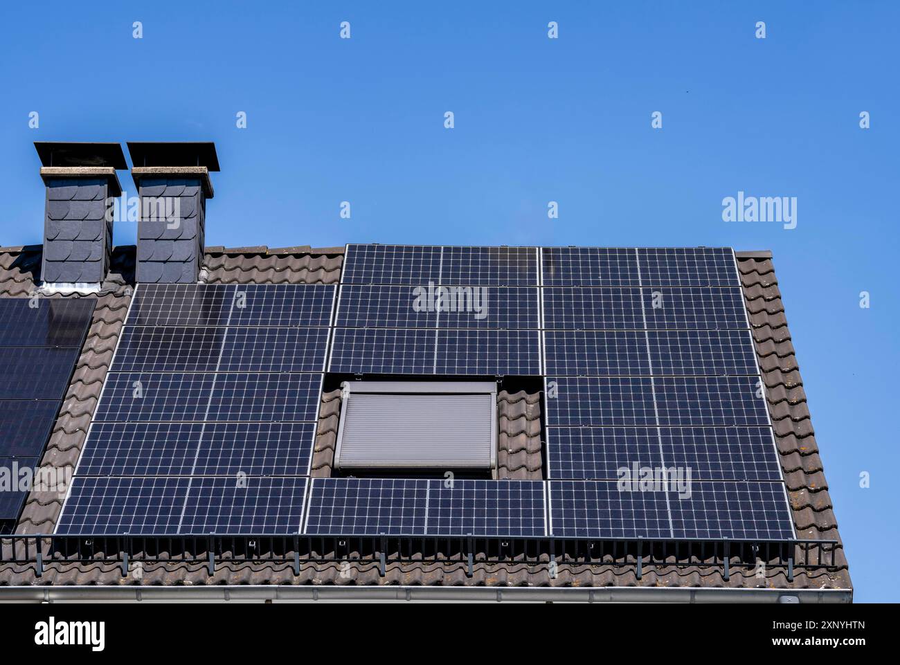 Solaranlage auf dem geneigten Dach eines Wohngebäudes, Photovoltaik zur Stromerzeugung, für den Eigenverbrauch und Netzeinspeisung, Nord Stockfoto