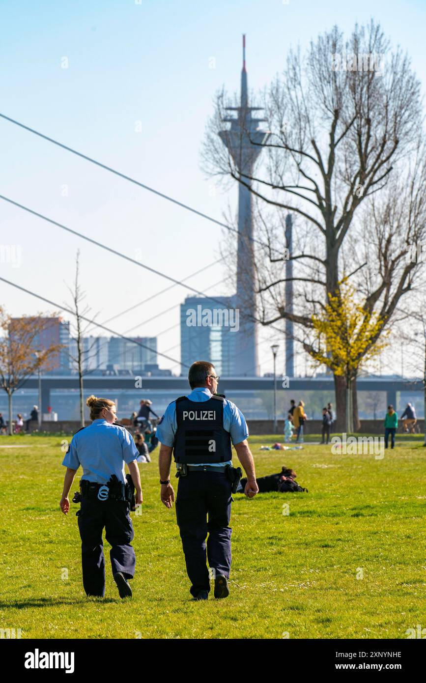 Polizeipatrouille überwacht das Kontaktverbot, Rheinpark, Düsseldorf am Rhein während der Coronakrise, die Kontaktverbote, Distanz ist meist Stockfoto