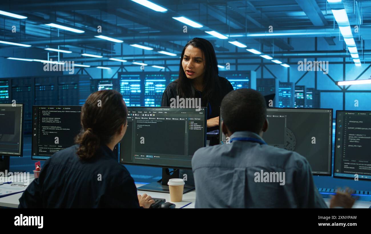 Manager überwacht den Serverraum, geht mit Checkliste auf dem Laptop herum, Fehlerbehebung bei Hardware und diskutiert mit Mitarbeitern. Vorgesetzter führt Inspektionen im Server-Hub durch und nimmt Feedback von Mitarbeitern ein Stockfoto