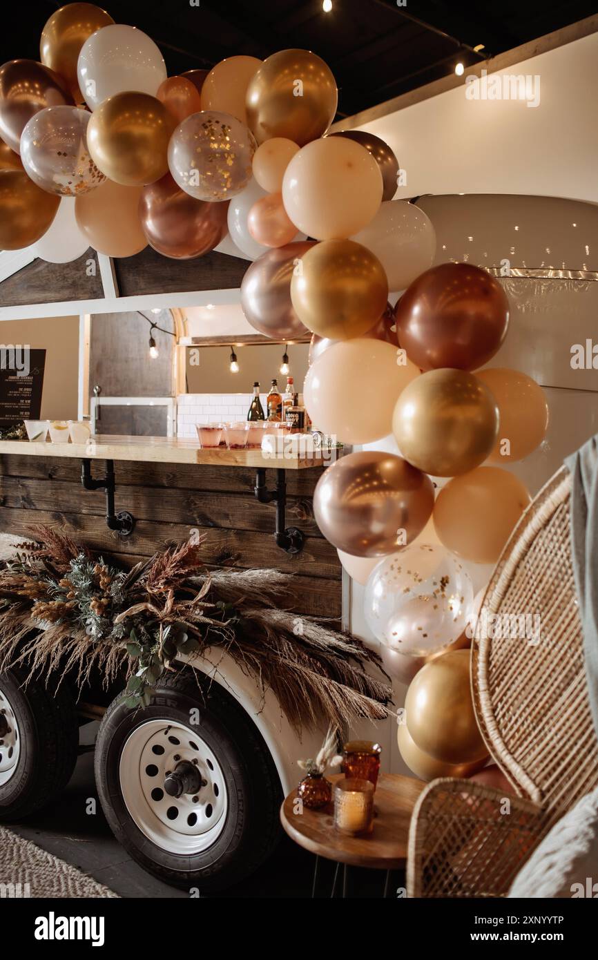 Hochzeit, Party Event, Mobile Bar Trailer, Ballonbogen Boho Blumendekor, Hochzeitsambiente, neutrale Farben, Boho Pferd Trailer Bar Stockfoto