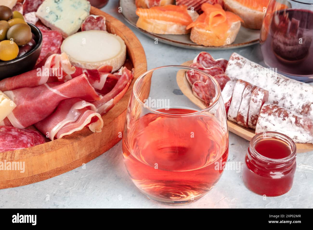 Rosenwein mit Wurstwaren, Käse und Lachs-Sandwiches. Spanische Tapas. Jamon, Fuet, Ziege, Blauschimmelkäse und Oliven Stockfoto