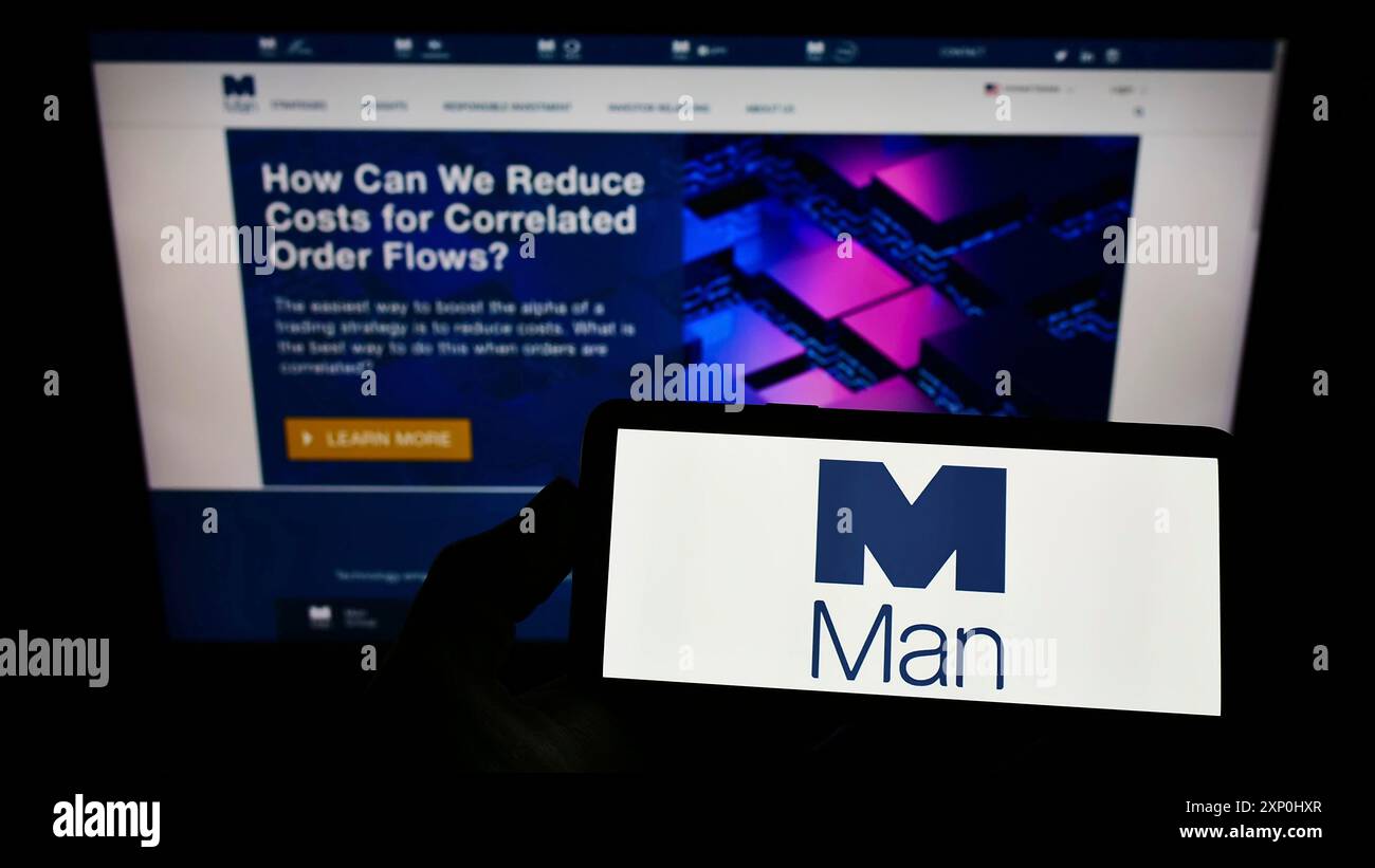Stuttgart, Deutschland, 02.06.2022: Person, die ein Smartphone mit dem Logo des britischen Finanzunternehmens man Group plc auf dem Bildschirm vor der Website hält. Fokus Stockfoto