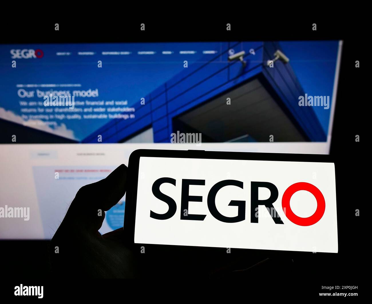 Stuttgart, Deutschland, 29.01.2022: Person, die ein Mobiltelefon mit dem Logo der britischen Immobilieninvestmentgesellschaft SEGRO plc auf dem Bildschirm vor dem Internet hält Stockfoto