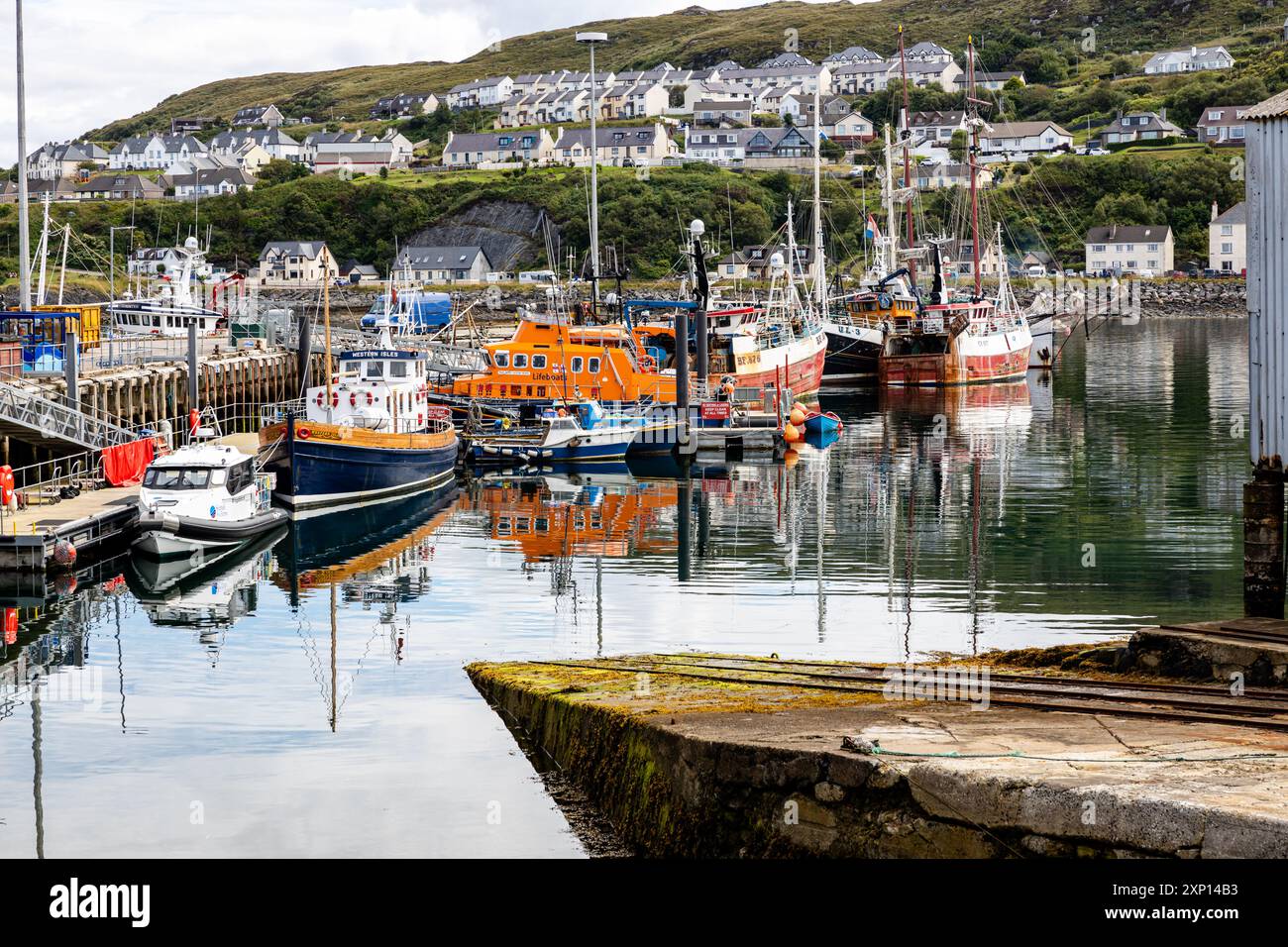 Geschäftige Hafenszene in der Highland-Region Schottlands, mit dem RNLI's RNLB The Henry Alston im Blick. Mallaig Harbour, Lochaber, Inverness-shire Stockfoto