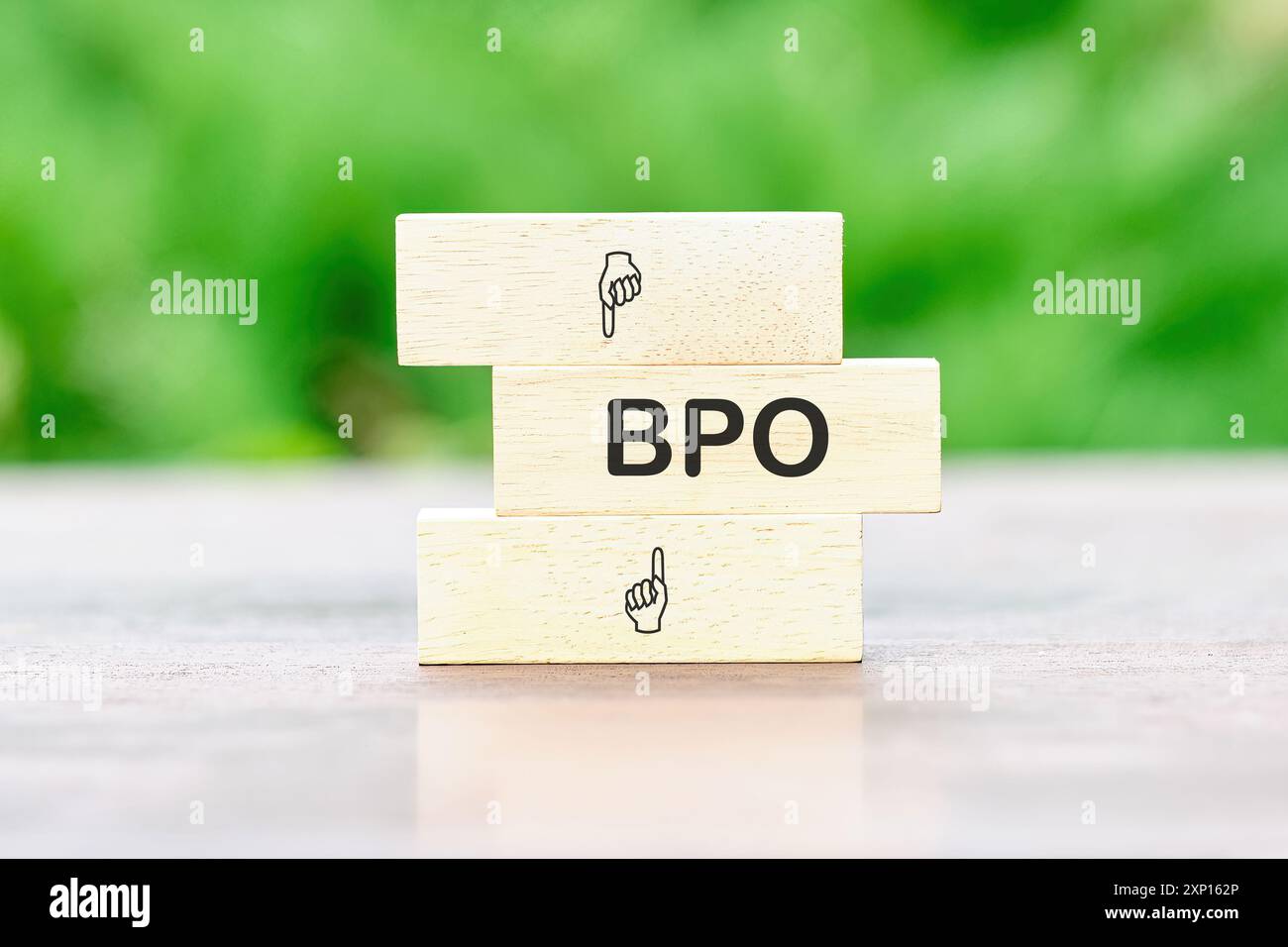 Geschäftskonzept. Buchstaben BPO. Business Process Outsourcing auf Holzstangen vor dem Hintergrund grüner Pflanzen ohne Fokus Stockfoto