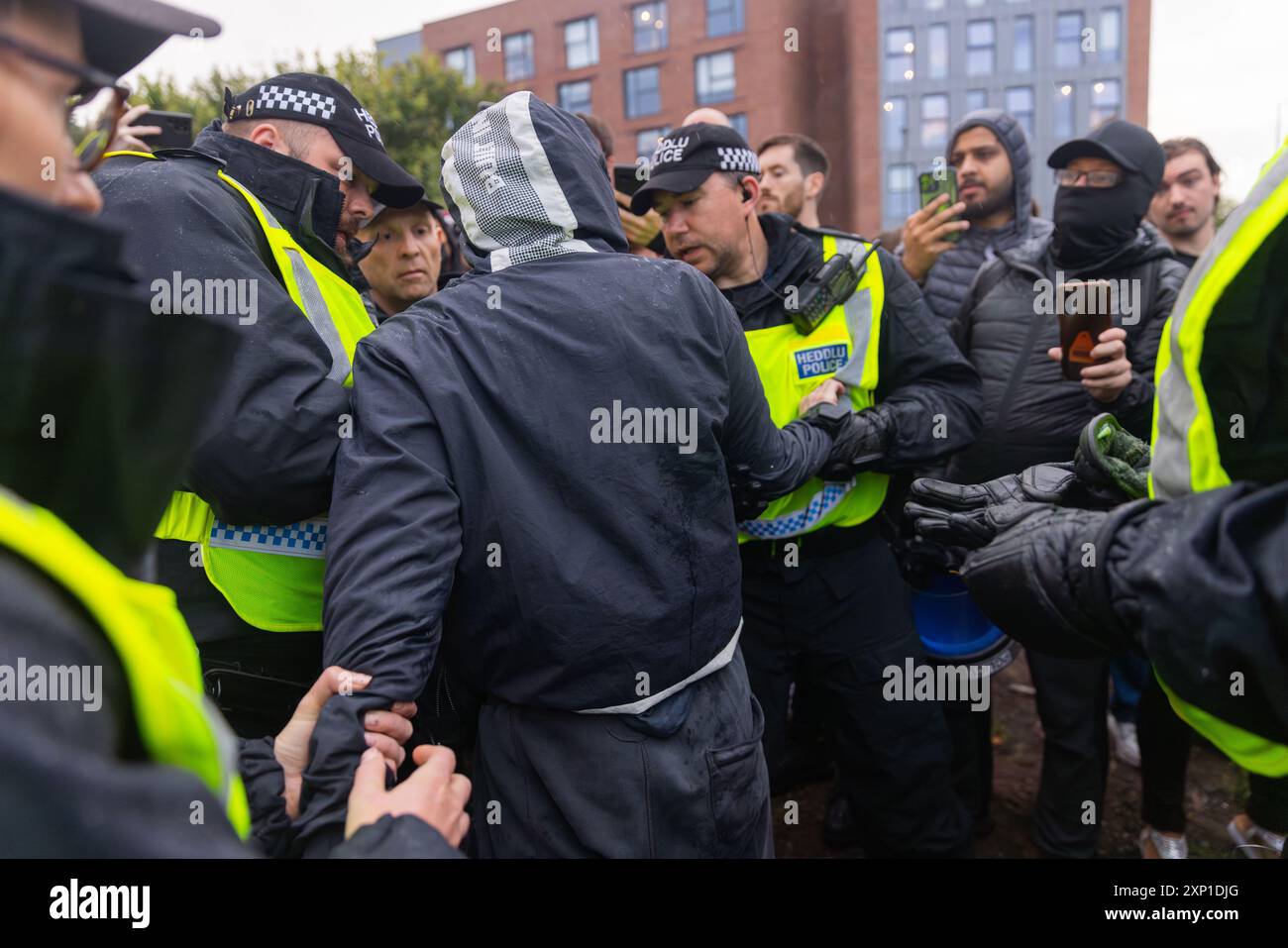 Liverpool, Großbritannien. AUGUST 2024. Der Mann wird angehalten und von der Polizei durchsucht, weil er befürchtet, dass er eine versteckte Waffe hat. Der Mann wurde nicht verhaftet und freigelassen. Demonstranten, die sich als rechter Flügel identifizierten, sowie Mitglieder von SUTR- und Linksorganisationen versammelten sich auf gegenüberliegenden Seiten der Straße vor der Abdullah Quilliam Moschee, einer der ersten Moscheen in England, vor dem Hintergrund von Unruhen im ganzen Land nach einem Vorfall in Southport. Abgesehen von einigen Schreien und Demonstranten, die kurz die Seite überquerten, wurden keine Probleme beobachtet. Credit Milo Chandler/Alamy Live News Stockfoto