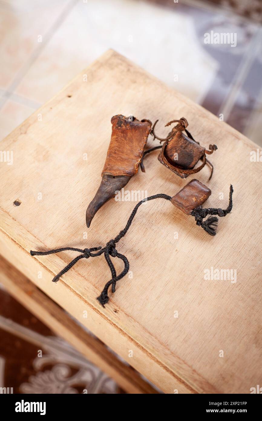 Nahaufnahme traditioneller Voodoo-Artefakte auf einer hölzernen Oberfläche, die spirituelle Rituale und kulturelle Überzeugungen in Gambia symbolisieren. Stockfoto