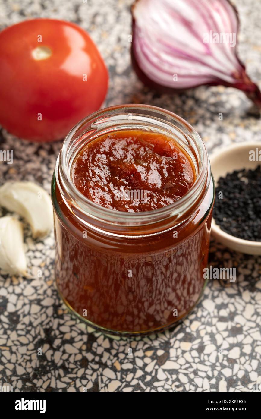 Glas mit Tomatenzwiebelchutney und nigella-Samen für eine Beilage Stockfoto