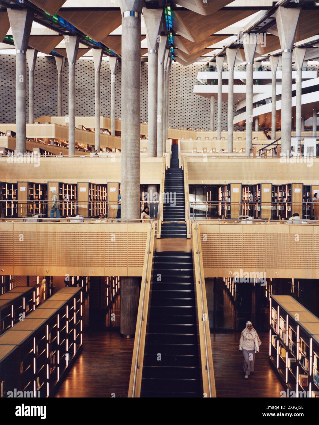 Atemberaubendes modernes Interieur der Bibliotheca Alexandrina in Alexandria, Ägypten, mit einer großen Treppe und umfangreichen Bücherstapeln. Stockfoto