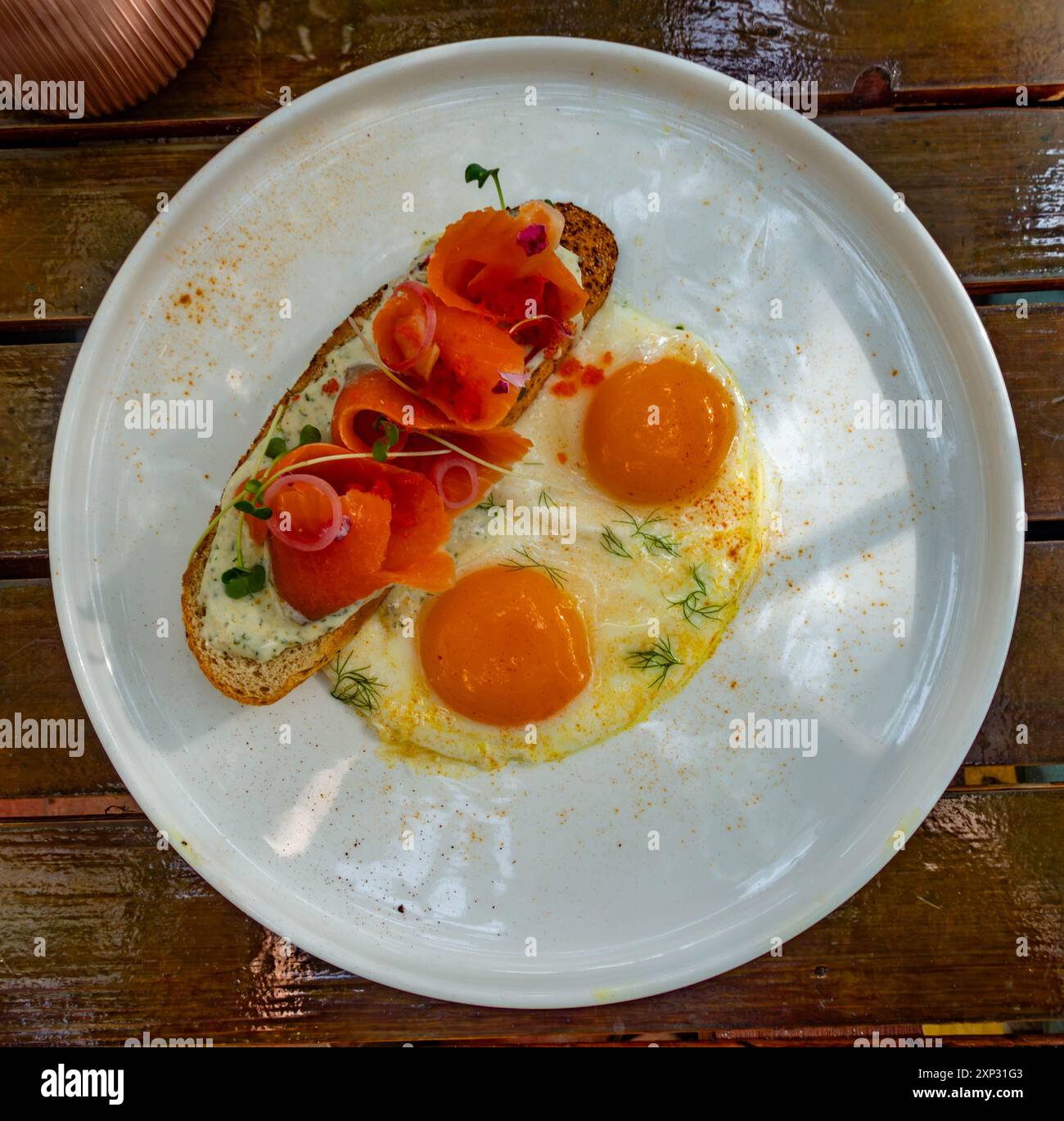 Geräucherter Lachs auf Toast mit Spiegeleiern zum Frühstück in einem Restaurant während des Urlaubs. Stockfoto