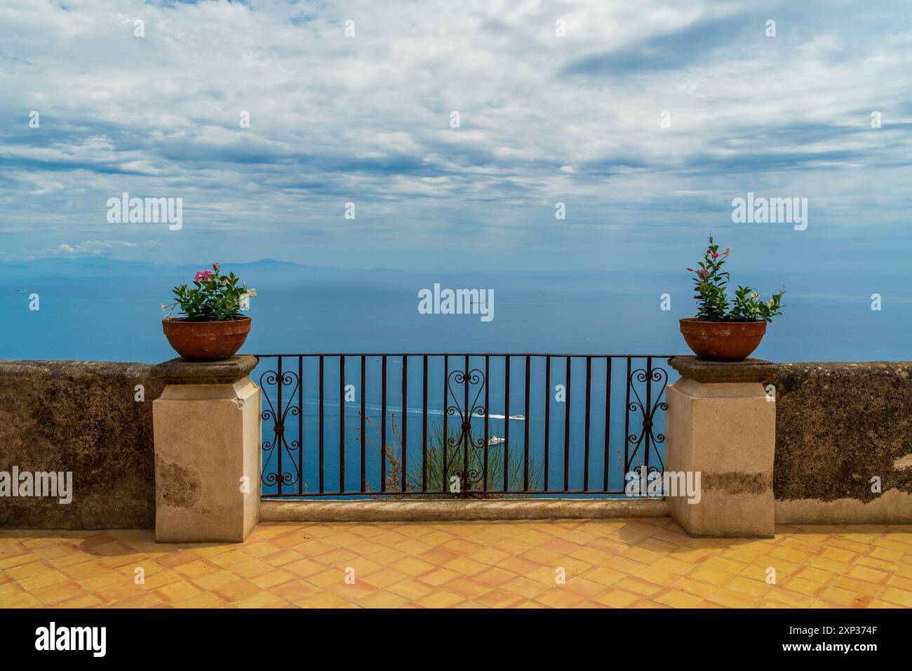 Ravello, Terrasse der Unendlichkeit, Gärten der Villa Cimbrone in Italien: Eine ruhige Terrasse mit Blumentöpfen auf Säulen, mit Blick auf den riesigen blauen Ozean darunter Stockfoto