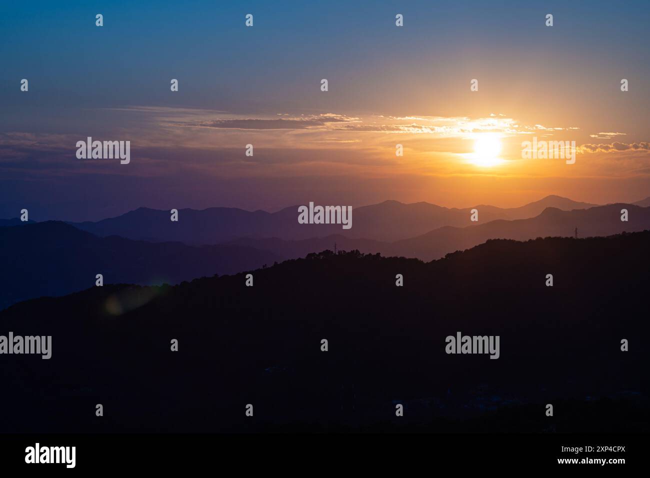 Wunderschöner Blick auf die untergehende Sonne über den mehrschichtigen Hügeln im hohen Norden der Toskana, Italien. Stockfoto