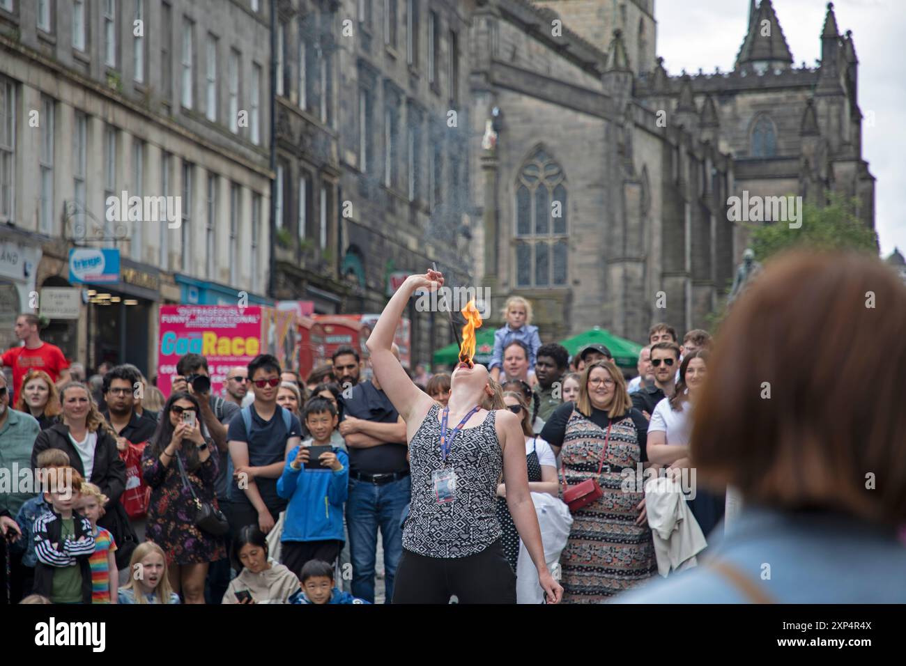 Edinburgh Fringe, Royal Mile, Schottland, Großbritannien. 3. August 2024. Geschäftiger Nachmittag auf der High Street am ersten Wochenende. Im Bild: Lygia aus Kanada isst Feuer auf der High Street. Quelle: Arch White/Alamy Live News. Stockfoto