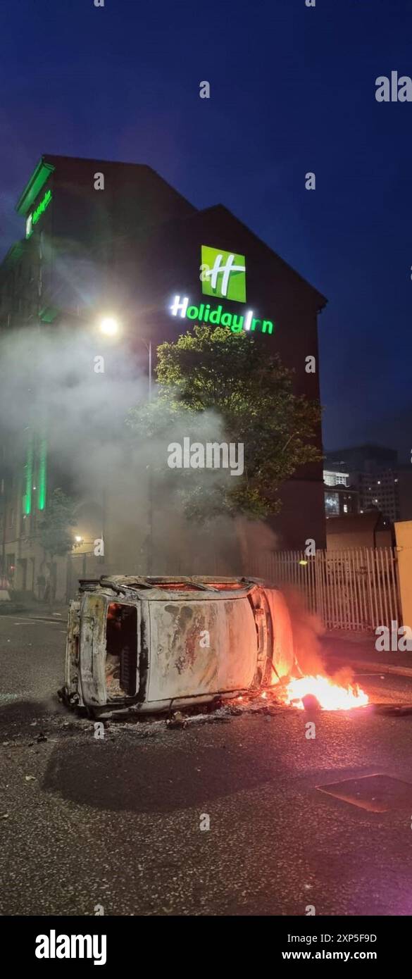 Nach einem antiislamischen Protest vor dem Rathaus von Belfast wird ein Fahrzeug in Belfast angezündet. Bilddatum: Samstag, 3. August 2024. Stockfoto