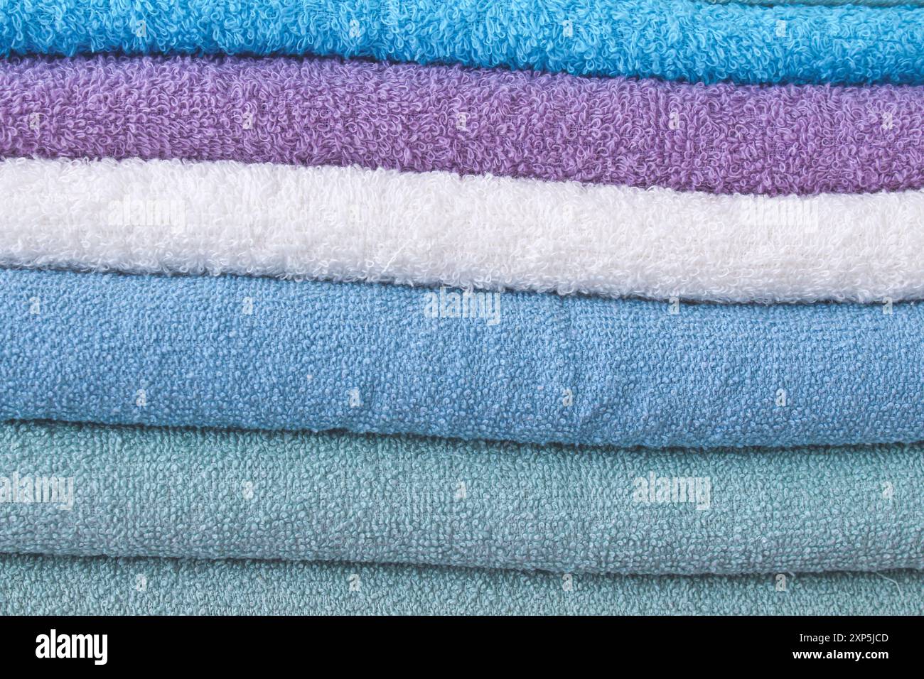 Bunte Handtücher übereinander gestapelt. Nahaufnahme und voller Bildschirm. Stockfoto