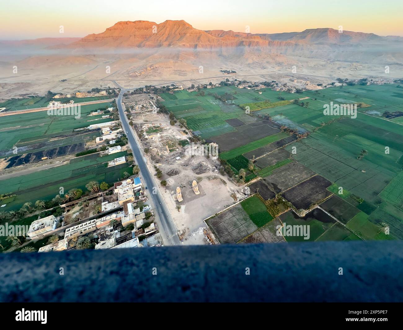 Entdecken Sie die alten Wächter von Luxor aus einer neuen Höhe. Dieses Luftbild zeigt die Memnon-Kolosse, die hoch und stolz über dem Niltal stehen Stockfoto