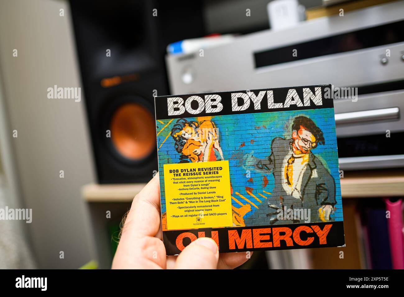 Paris, Frankreich - 18. März 2024: Männliche Hand hält Bob Dylans „Oh Mercy“ SACD aus der Revisited-Serie mit einem Hi-fi-Audio-Setup im Hintergrund Stockfoto