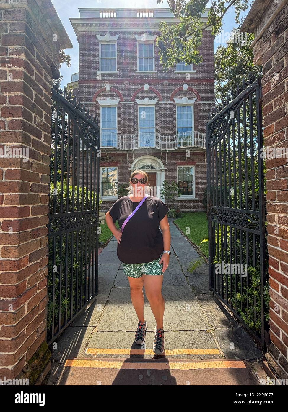 Frau steht am Eingangstor des Nathaniel Russell House in Charleston, SC Stockfoto