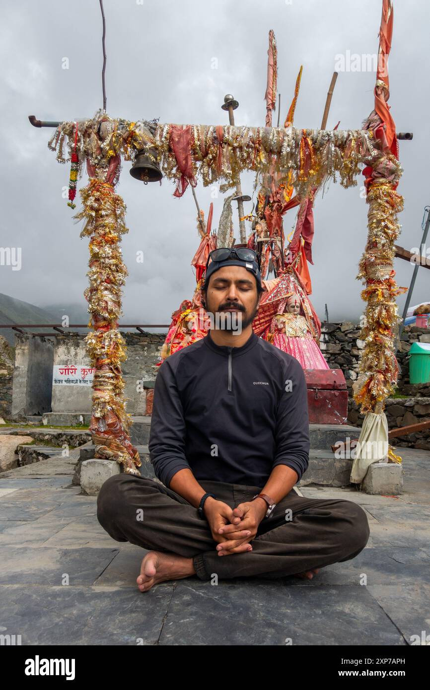 Juli 25.2024, Himachal Pradesh, Indien. Gläubige in meditativen Haltungen am Gauri Kund, einem heiligen Teich, der der hinduistischen Göttin Gauri Mata gewidmet ist, während der Stockfoto